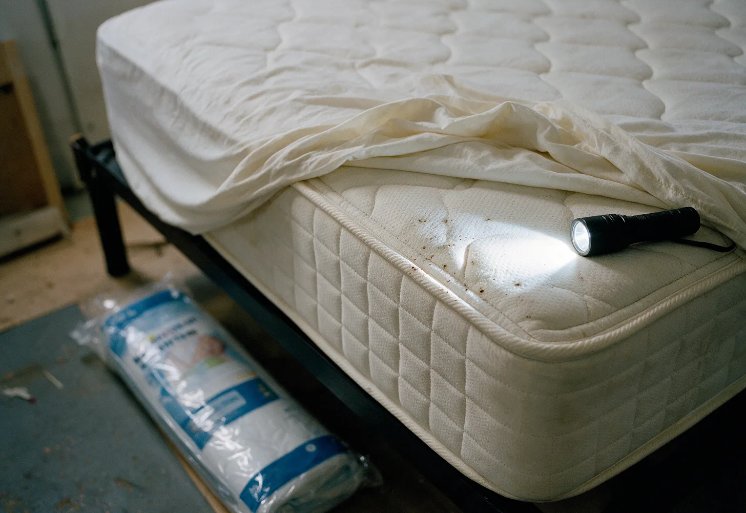 A mattress seam checked with a flashlight