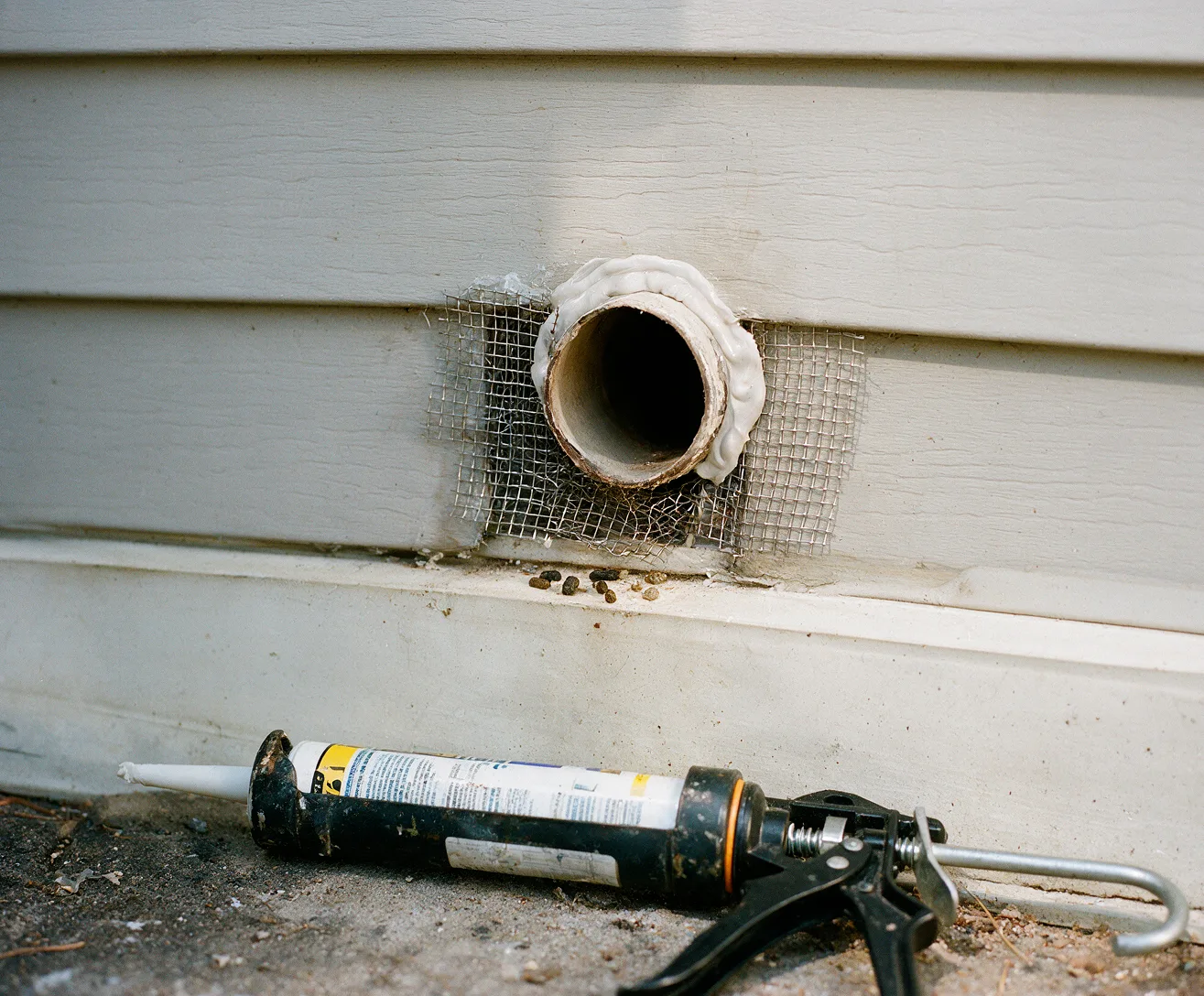 Steel mesh sealing a gap around a pipe in siding